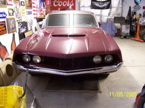 1971 Ford Ranchero - Front view of a maroon car, possibly a 1970 model, in a garage.