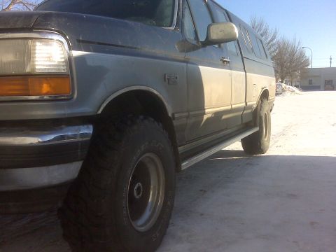 1994 Ford F-150 - This Ford F-150 pickup truck, equipped with a camper shell, is viewed from its front quarter on a bright, cold day.