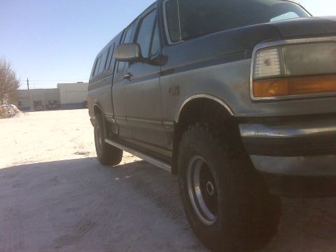 1994 Ford F-150 - This pickup truck, identified as a 1994 Ford F-150, is seen from the side with a camper shell installed.