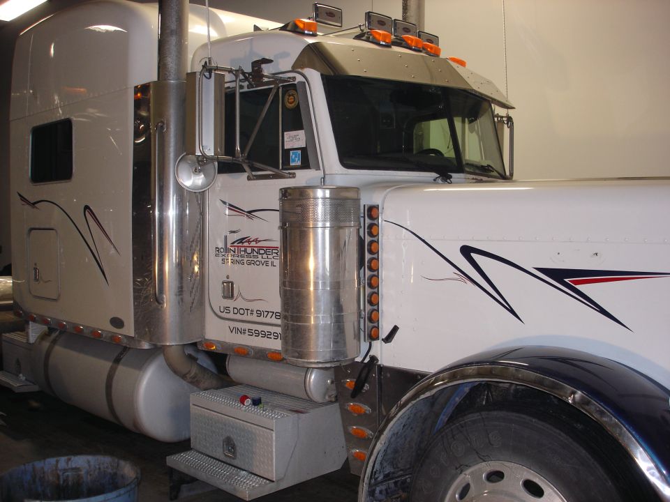 White semi-truck cab with custom graphics and chrome stacks