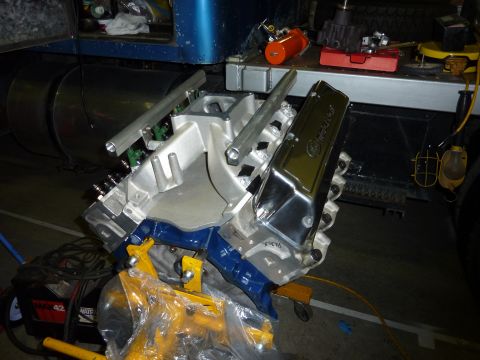 1971 Ford Mustang - Engine part on a stand, likely a Ford V8, with chrome valve covers and aluminum intake manifold.