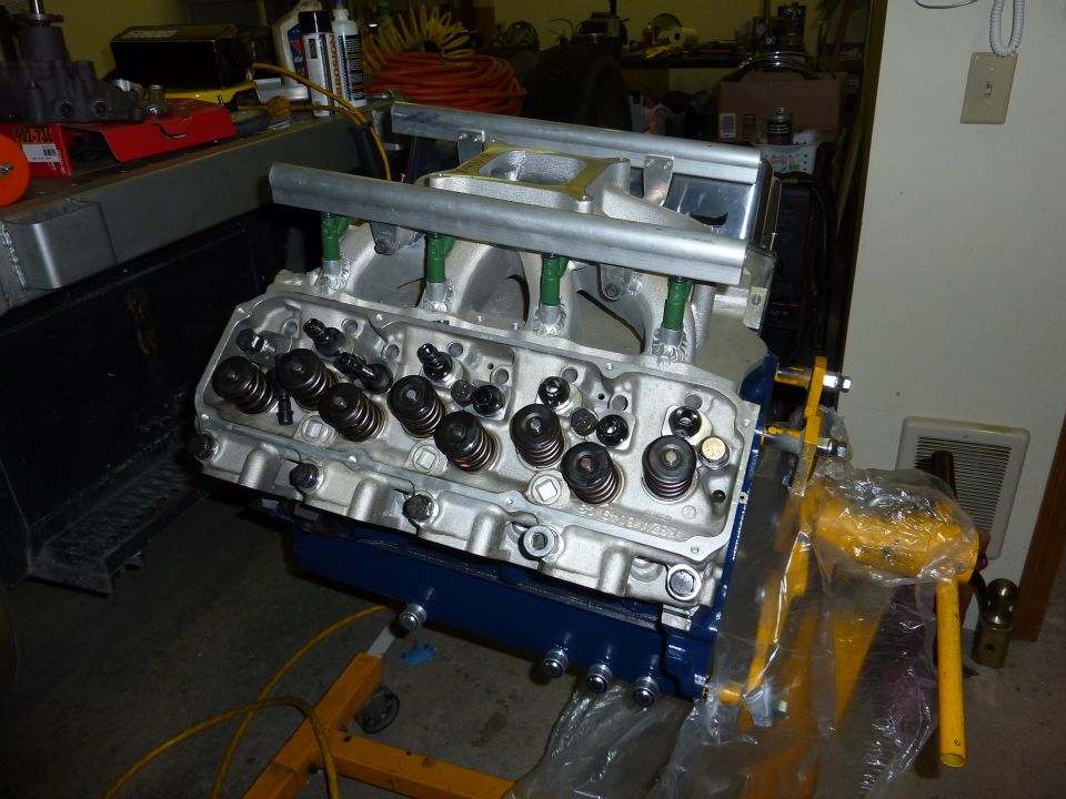 V8 engine block on an engine stand, with intake manifold and fuel injectors attached