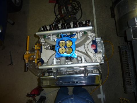 1971 Ford Mustang - Close-up of a Ford Motorsport engine part, likely an intake manifold and valve covers, with a blue throttle body.