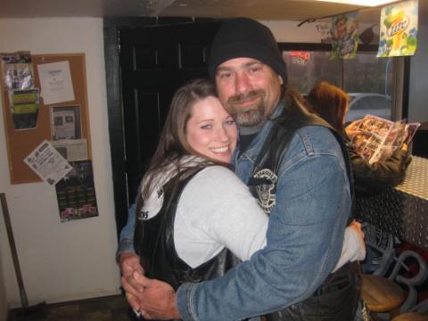 2006 Harley-Davidson Sportster Custom - A couple embraces in a bar, with a bulletin board on the wall behind them.