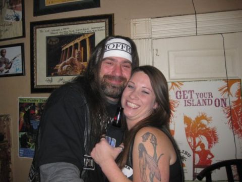 2006 Harley-Davidson Sportster Custom - Couple poses for a photo in front of posters on a wall.