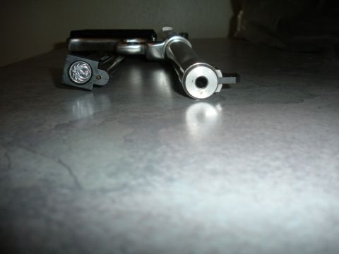 1996 Ford Bronco - A close-up view of a pistol, with its magazine detached, rests on a textured surface.