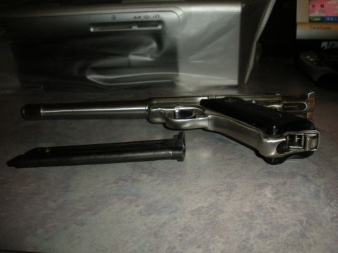 1996 Ford Bronco - A handgun and its magazine are displayed on a table, with a computer monitor visible in the background.