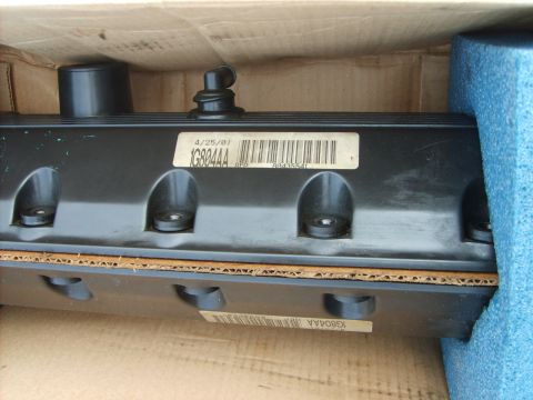 1993 Ford Crown Victoria - A valve cover is shown in its packaging, with a date and part number visible on a label.