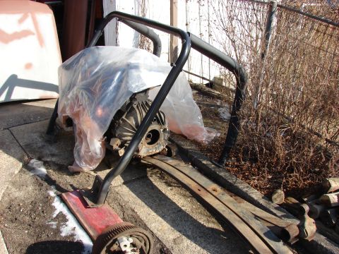1996 Jeep Grand Cherokee - A transmission and roll cage are shown outdoors, resting on leaf springs and a dolly.