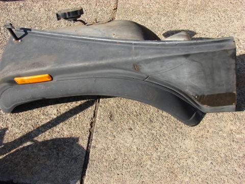 1996 Jeep Grand Cherokee - A gray plastic fender flare with an amber marker light and a black cap is shown on a concrete surface.