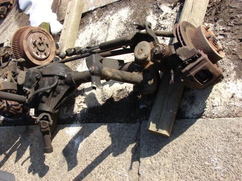 1996 Jeep Grand Cherokee - Front axle assembly with differential, brake rotors, and calipers. Part of a vehicle's suspension system.