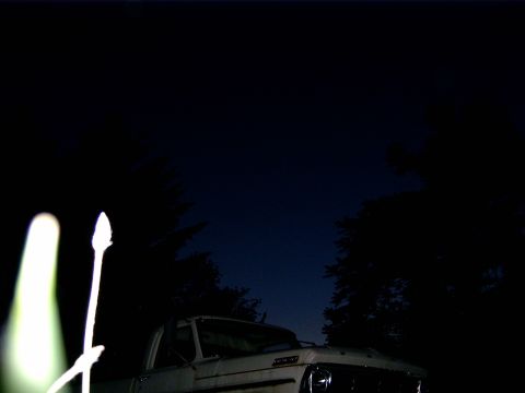 1988 Ford Bronco - A white truck is seen from the front at night, with trees silhouetted against the dark sky.