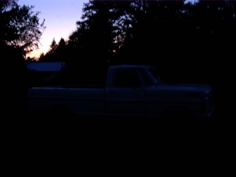 1988 Ford Bronco - Side view of a pickup truck parked outdoors during twilight.