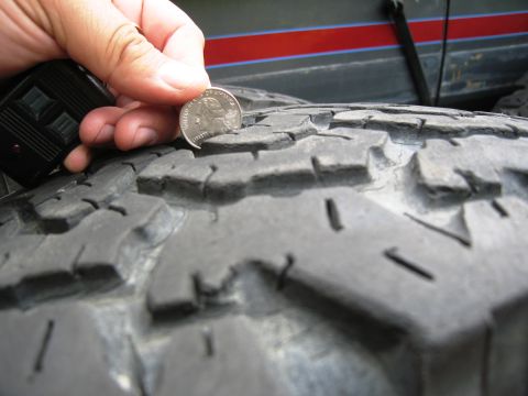 1986 Ford Bronco - Checking tire tread depth with a quarter.