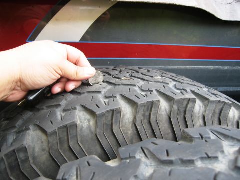 1986 Ford Bronco - Checking tire tread depth with a coin.