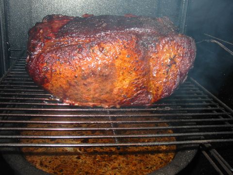 1992 Ford Bronco - A large cut of meat is being smoked on a metal rack, with smoke visible.