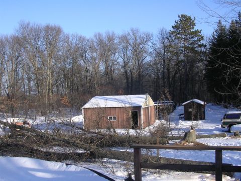 1978 Ford Bronco - A green van is visible in a snowy yard, with several large trees fallen across the scene.