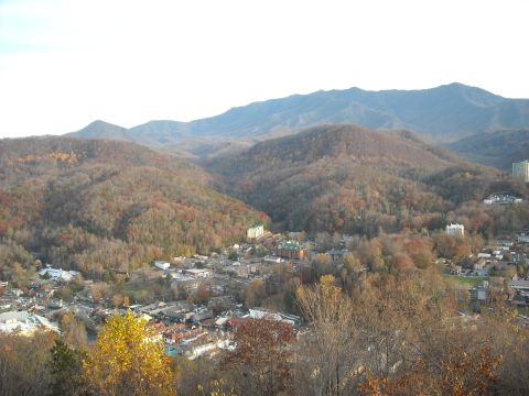 1979 Ford F-150 - A scenic view of a town in a mountain valley during autumn, with colorful trees and distant peaks under a bright sky.