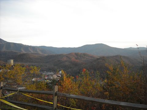 1979 Ford F-150 - A scenic view of rolling hills and a distant town, framed by autumn foliage and a wooden fence.
