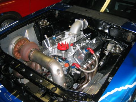 1992 Ford Mustang - The engine bay features a turbocharger and custom modifications, with blue paint and lightning bolt graphics on the exterior.