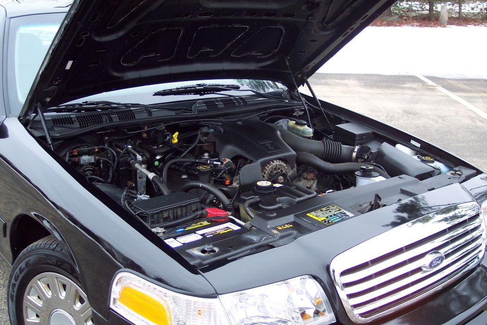 2001 Ford Crown Victoria engine bay with hood open, showing V8 engine and battery