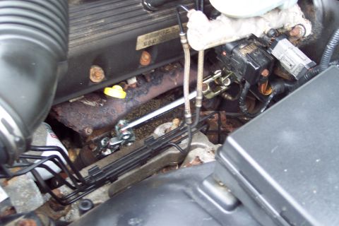 2001 Ford Crown Victoria - Close-up view of an engine bay, showing the exhaust manifold, fuel lines, and various electrical components.