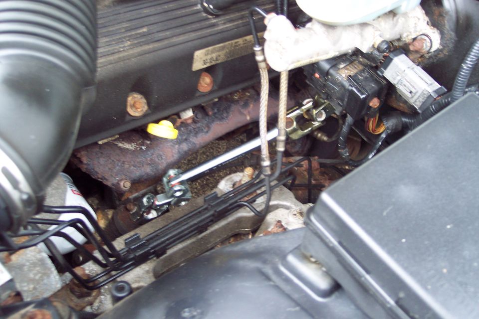 Engine bay with exhaust manifold, fuel lines, and electrical connectors