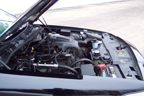 2001 Ford Crown Victoria - The engine bay of a 2001 Ford Crown Victoria is shown with the hood open, revealing the V8 engine and associated parts.