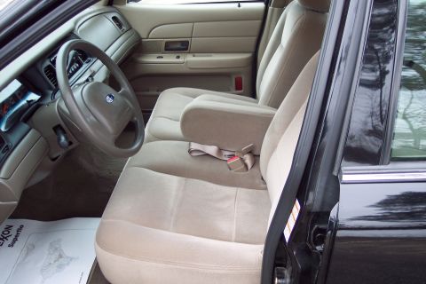2001 Ford Crown Victoria - The interior of a 2001 Ford Crown Victoria, cloth seats and a center console armrest.