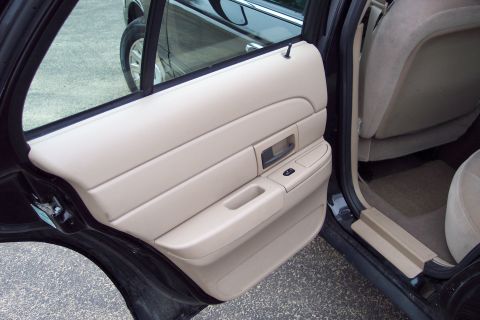 2001 Ford Crown Victoria - The interior of a 2001 Ford Crown Victoria shows a beige door panel and rear seat.