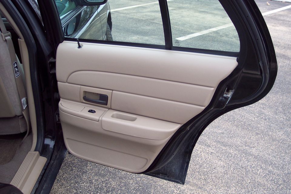 2001 Ford Crown Victoria interior door panel with tan upholstery and black trim