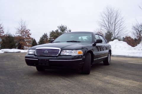 2001 Ford Crown Victoria - Front 3/4 view of a black 2001 Ford Crown Victoria sedan in a snowy outdoor setting.