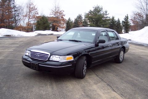 2001 Ford Crown Victoria - A black 2001 Ford Crown Victoria is parked in an empty lot during winter.
