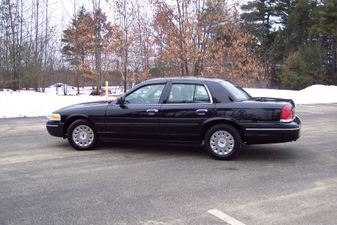 2001 Ford Crown Victoria - Side view of a black 2001 Ford Crown Victoria sedan in a parking lot during winter.