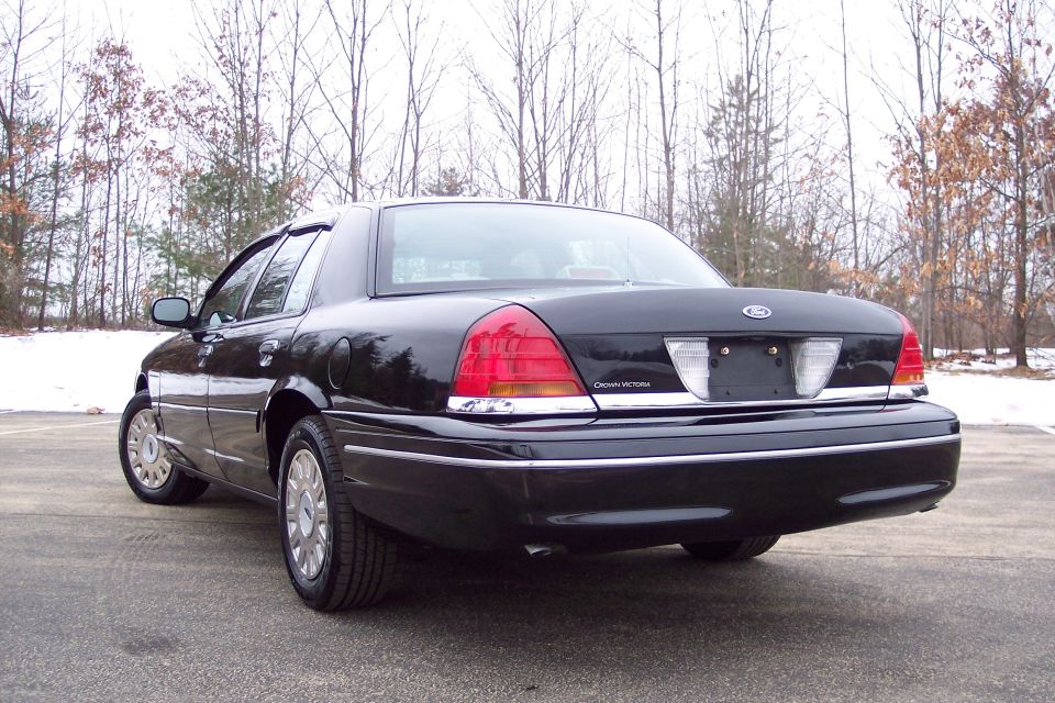 Black 2001 Ford Crown Victoria rear 3/4 view, chrome trim, on asphalt