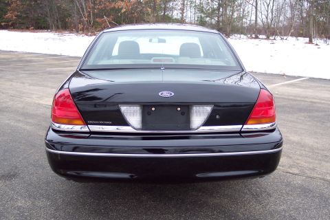 2001 Ford Crown Victoria - Rear view of a black Ford Crown Victoria, showing its distinctive taillights and chrome accents.