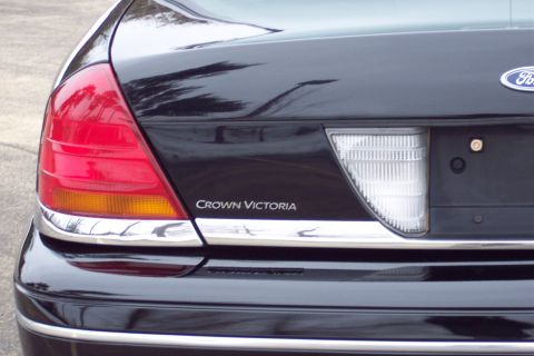 2001 Ford Crown Victoria - Rear view of a black 2001 Ford Crown Victoria, showing the taillight and model name badge.
