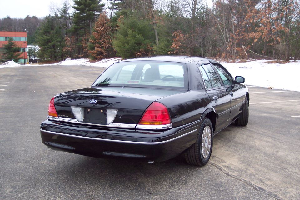 Black 2001 Ford Crown Victoria parked outside on a cloudy day