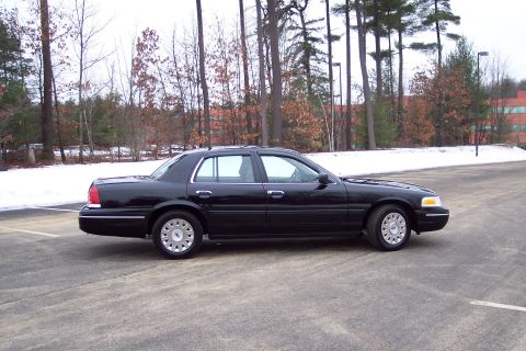 2001 Ford Crown Victoria - Side view of a black 2001 Ford Crown Victoria sedan in a parking lot during winter.