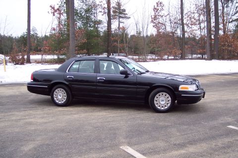 2001 Ford Crown Victoria - A black 2001 Ford Crown Victoria is shown from the side in a parking lot with a snowy background.