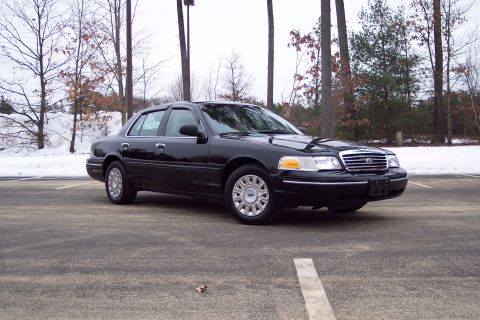 2001 Ford Crown Victoria - A black 2001 Ford Crown Victoria is viewed from the front three-quarter angle in a parking lot during winter.