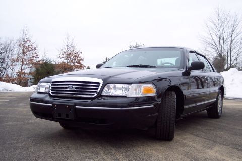 2001 Ford Crown Victoria - This black 2001 Ford Crown Victoria is shown from a 3/4 front angle on a paved surface with snow in the background.