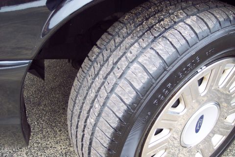 2001 Ford Crown Victoria - Close-up of a tire and wheel assembly, showing the Ford logo on the hubcap.