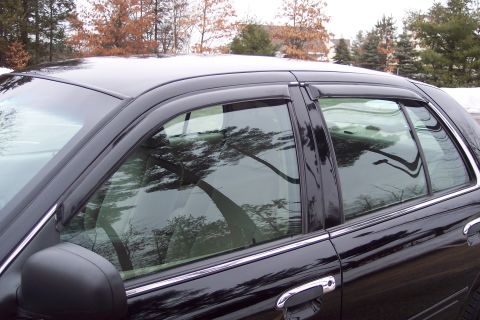 2001 Ford Crown Victoria - Side profile of a black 2001 Ford Crown Victoria, showing its distinctive body lines and chrome accents.