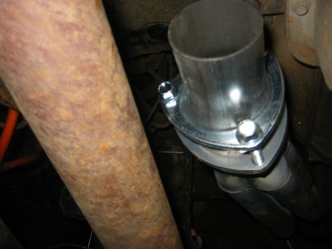 1995 Ford Bronco - A new exhaust flange connects two pipes under a vehicle.