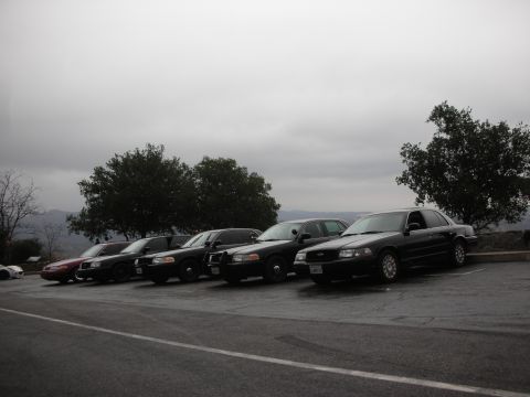1992 Ford Crown Victoria - Several police Crown Victorias are parked in a line on a cloudy day.