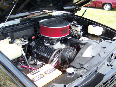 1990 Chevrolet Silverado 1500 - The engine bay of a 1990 Chevrolet Silverado 1500 shows a V8 engine with aftermarket modifications.