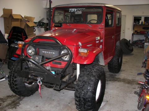 1990 Chevrolet Suburban - This red Toyota Land Cruiser FJ40 features a prominent winch and large off-road tires, suggesting it is built for terrain.
