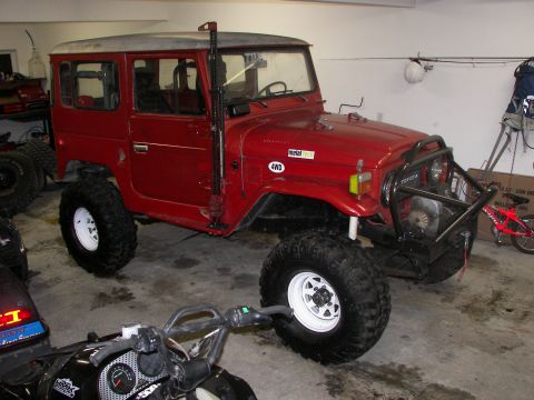 1990 Chevrolet Suburban - This modified Toyota Land Cruiser FJ40 is equipped with off-road tires and a snorkel, parked indoors.