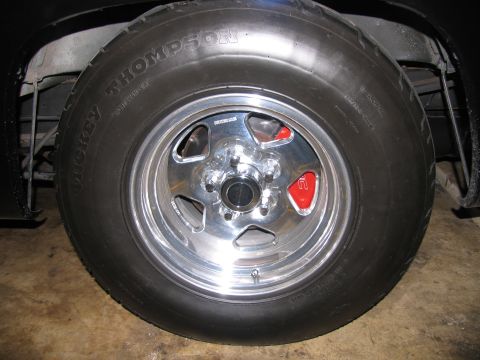 1990 Chevrolet Silverado 1500 - The wheel features a chrome finish and is equipped with red brake calipers, visible behind the spokes.